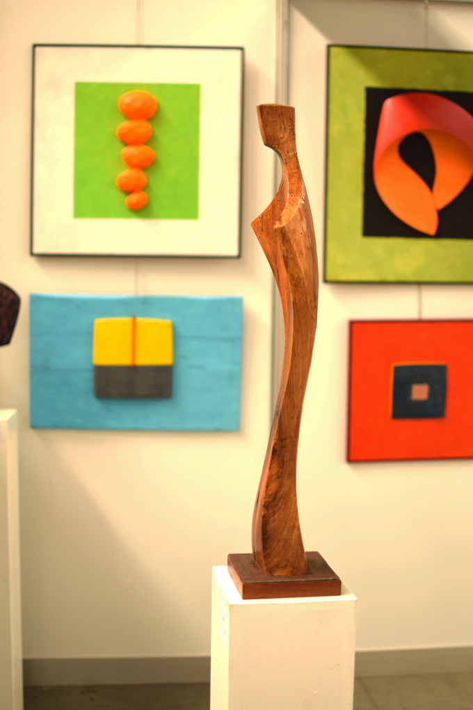 abstraktní obrazy a dřevěné plastiky z výstavy 